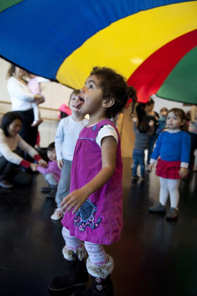 Toddler and friends at a music class with a parachute